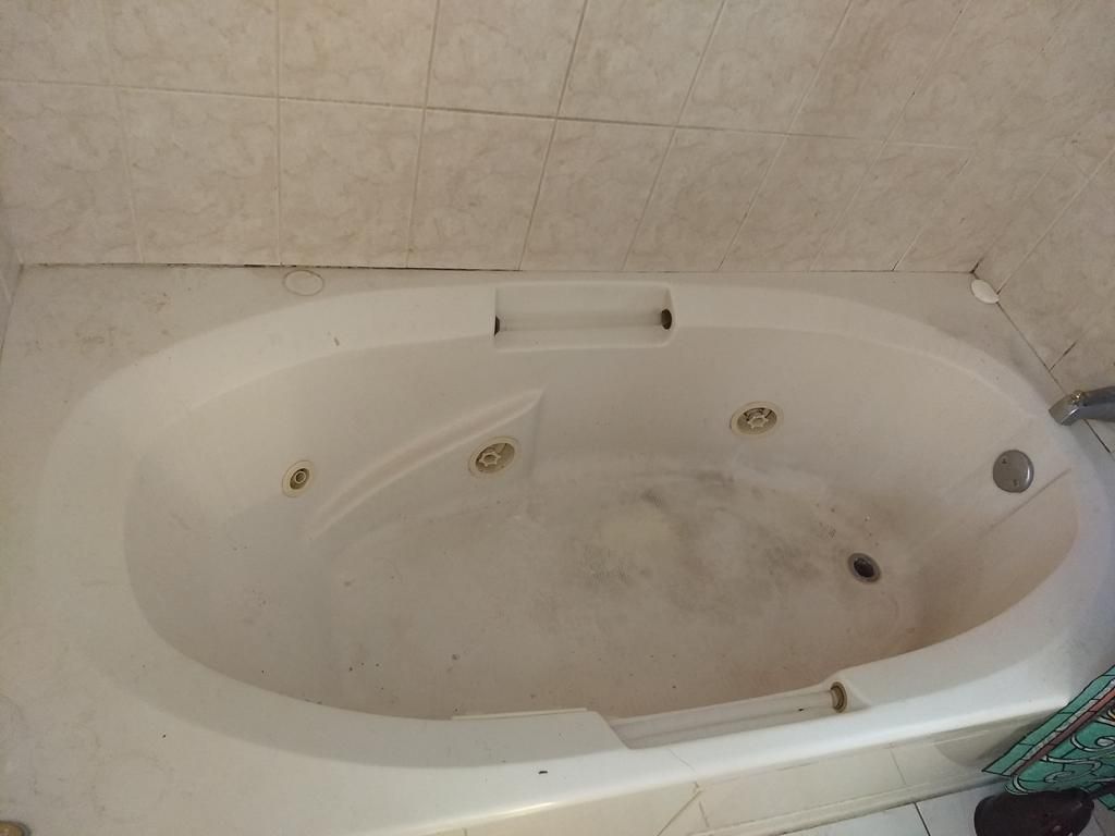 Jetted tub with dark residue rings before cleaning