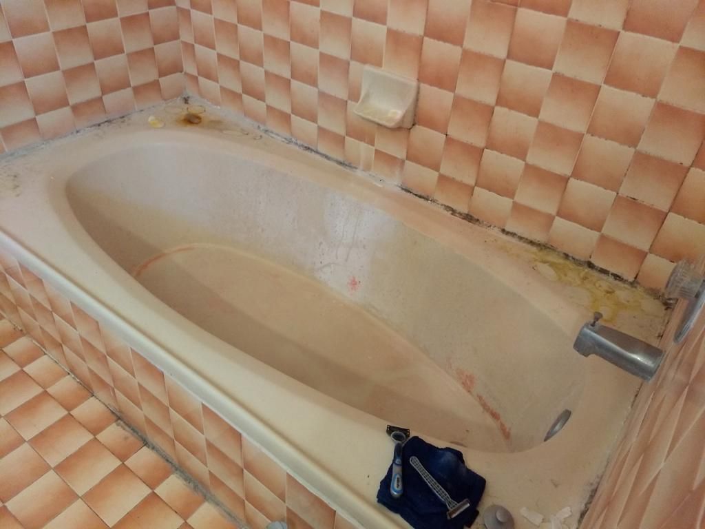 Heavily stained bathtub with brown buildup before cleaning